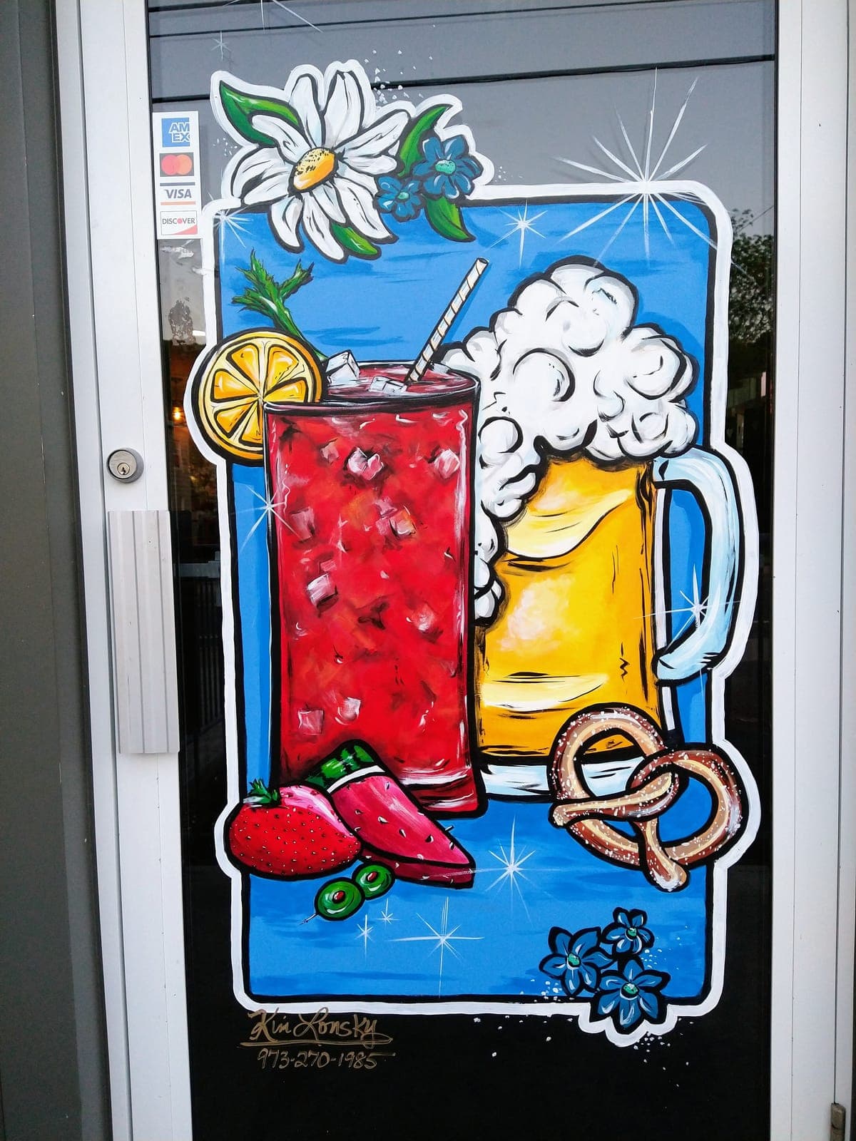 Summer cocktails, a frosty beer, and a soft pretzel painted on a bar window